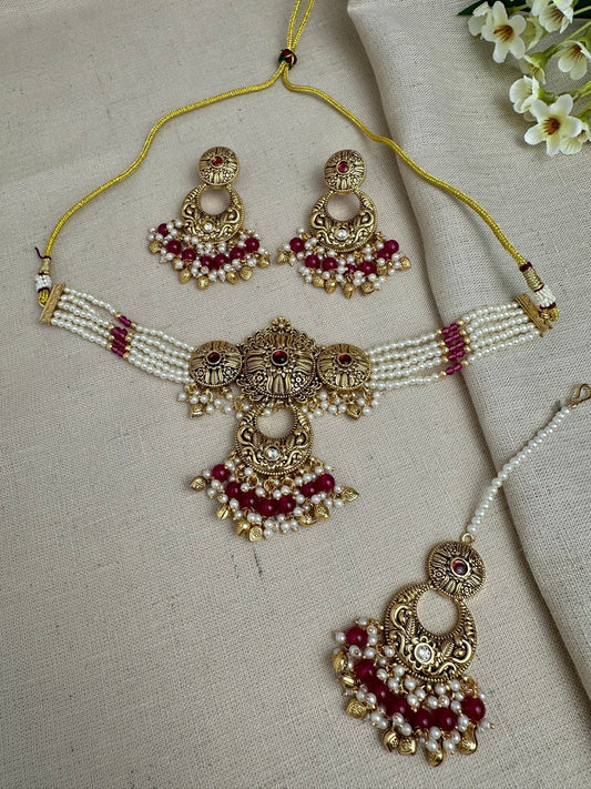     Aarohi antique gold pearl choker set in Ruby with earrings and maang tikka