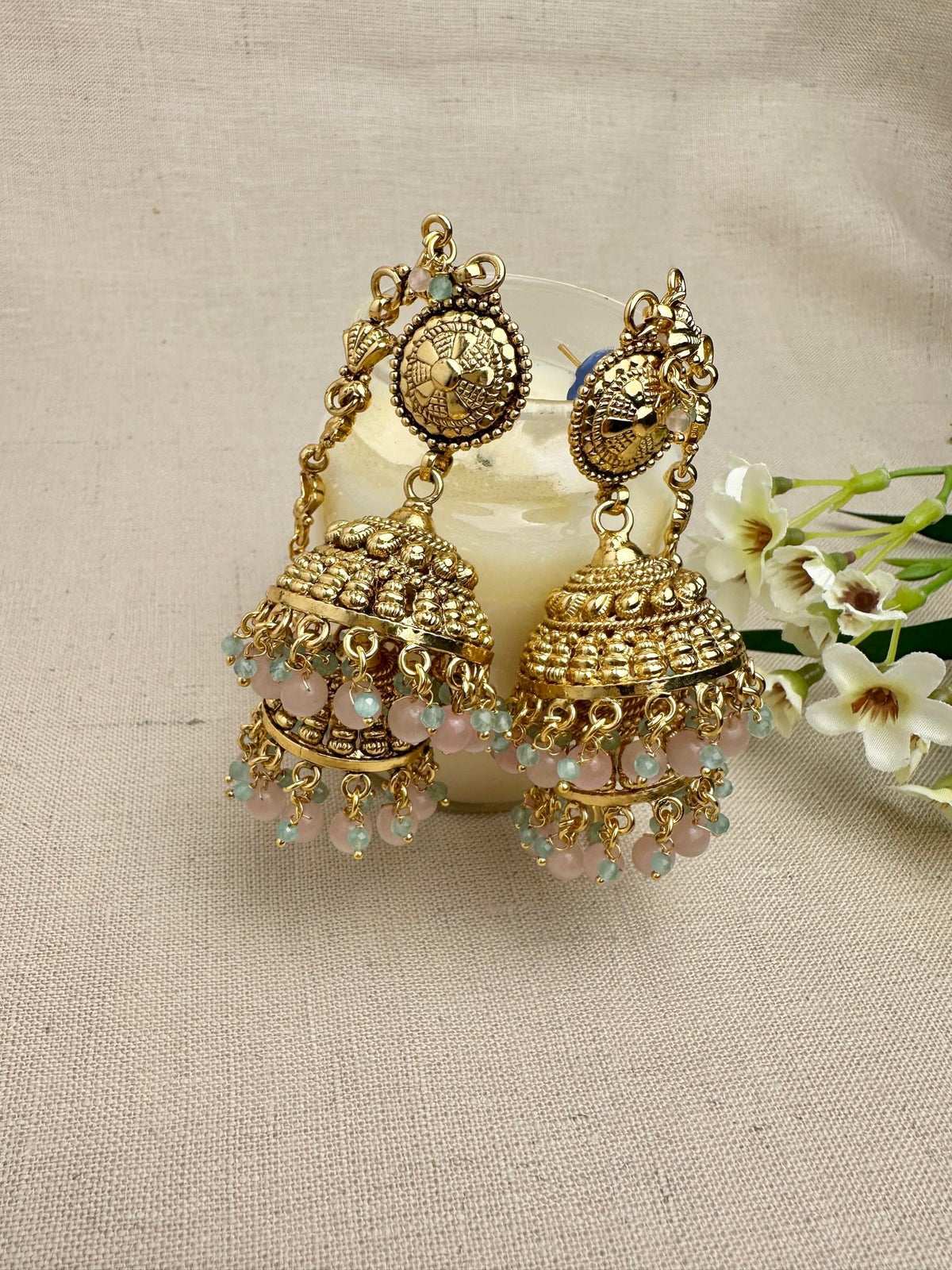 Close-up of the Aarohi Gold-Plated Punjabi jhumki earrings with pink and mint bead detailing.
