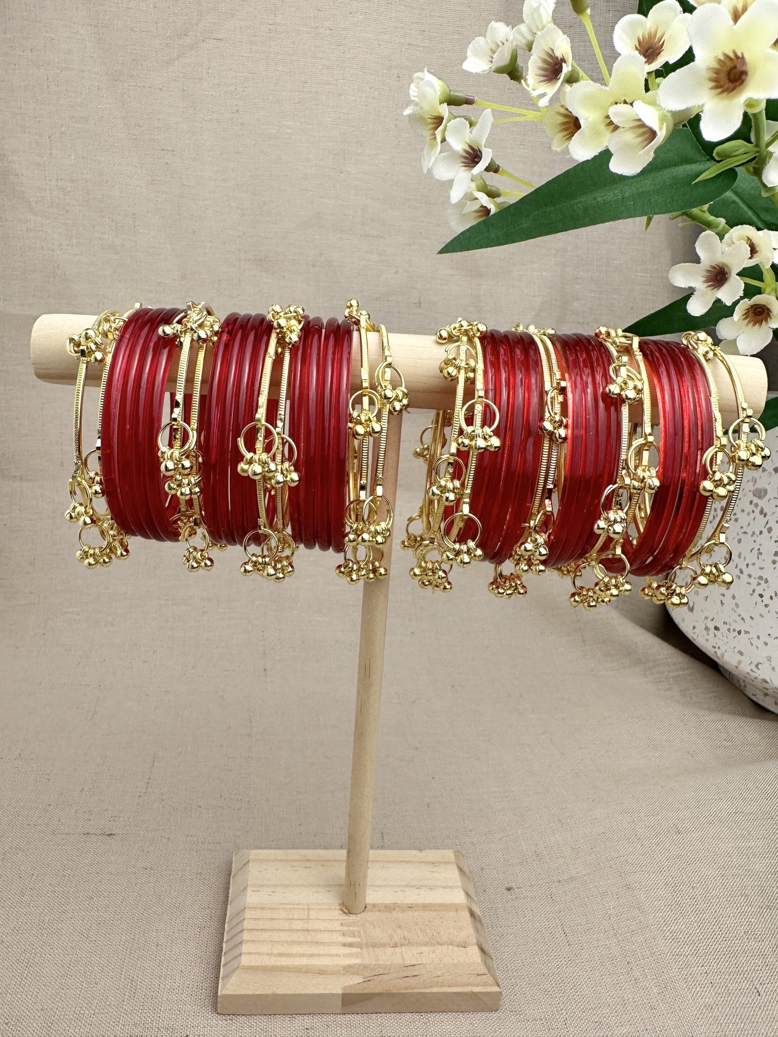 Aarohi Gold Ghungroo Bangles styled between red glass bangles for a layered festive look