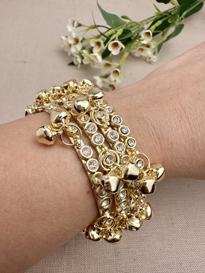 Four gold tone stone ghungroo bangles styled together on wrist