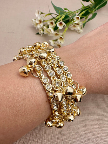 Four gold tone stone ghungroo bangles styled together on wrist