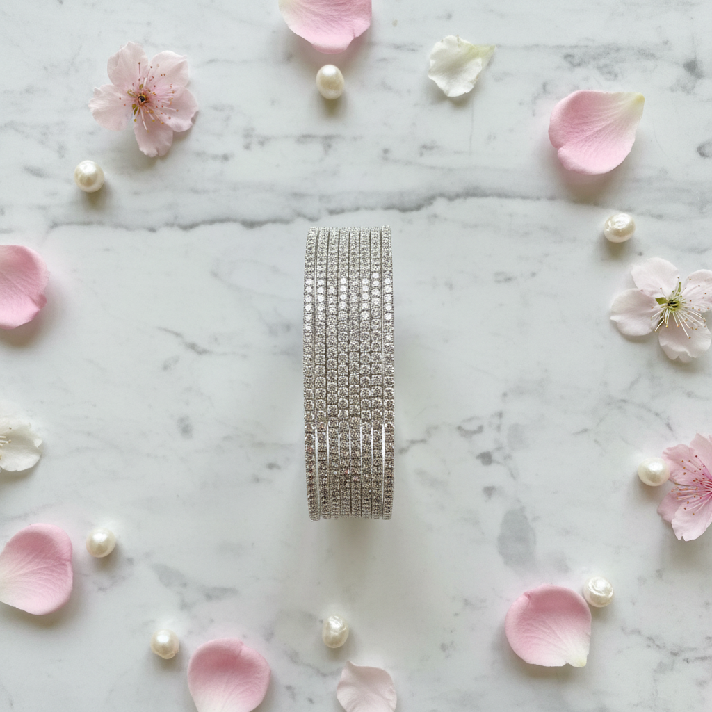 Sophia AD bangle set vertical flat lay with flower petals and pearls on marble