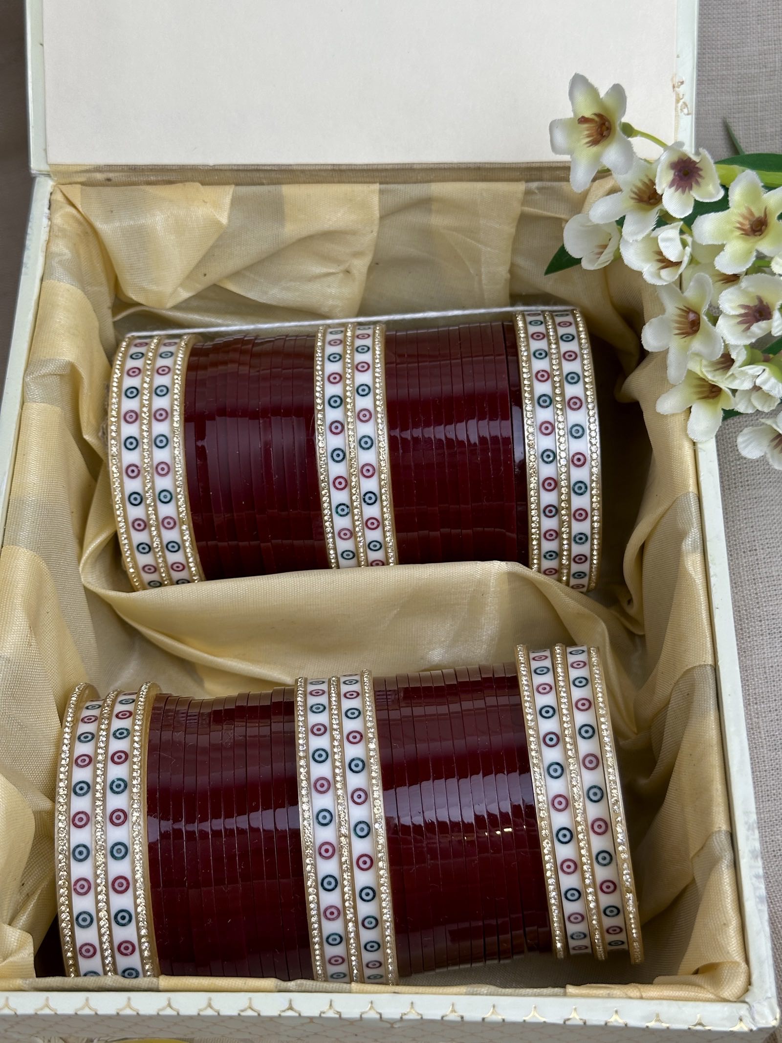 Complete maroon Punjabi chooda set for both arms arranged inside the included bridal box.