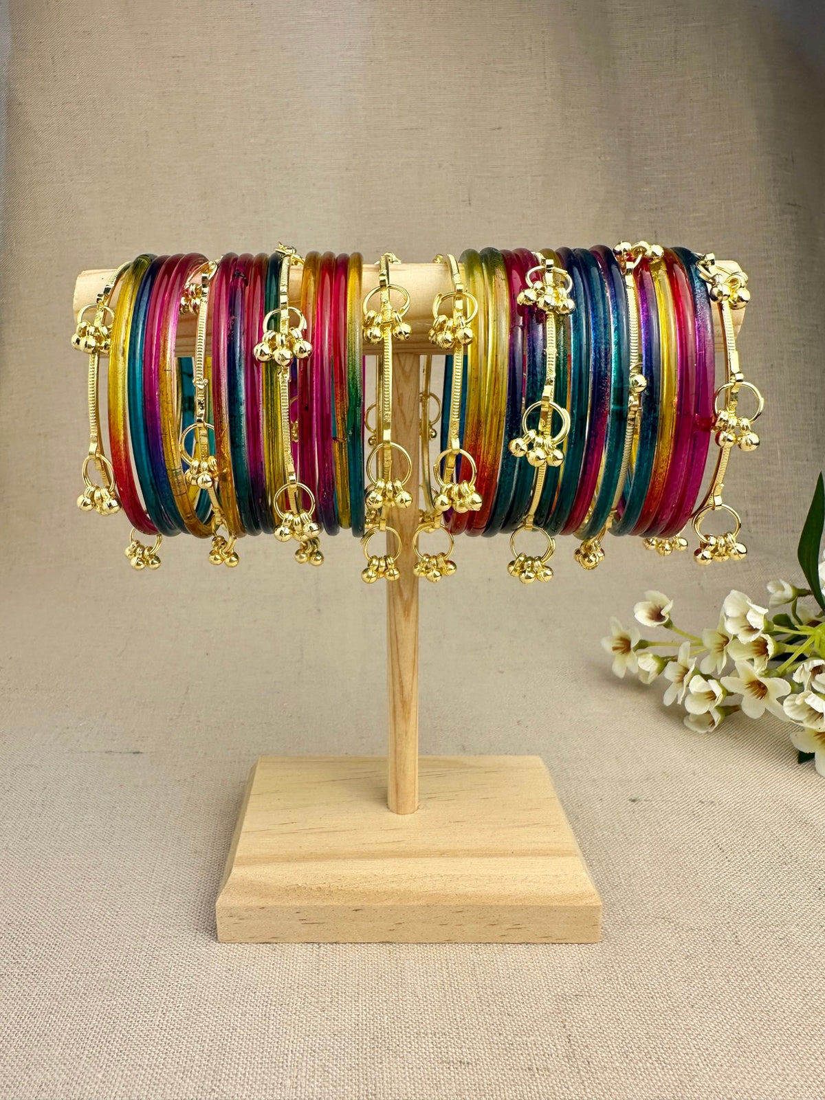 Mayra Dark Multicolor Jelly Bangles styled with gold-tone bangles and dangling ghungroo latkans in a traditional Indian jewellery look.
