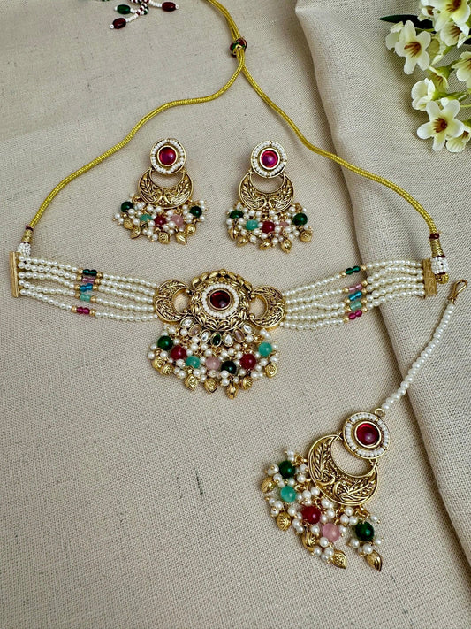 Antique gold-toned multicolour pearl choker set with matching earrings and maang tikka.