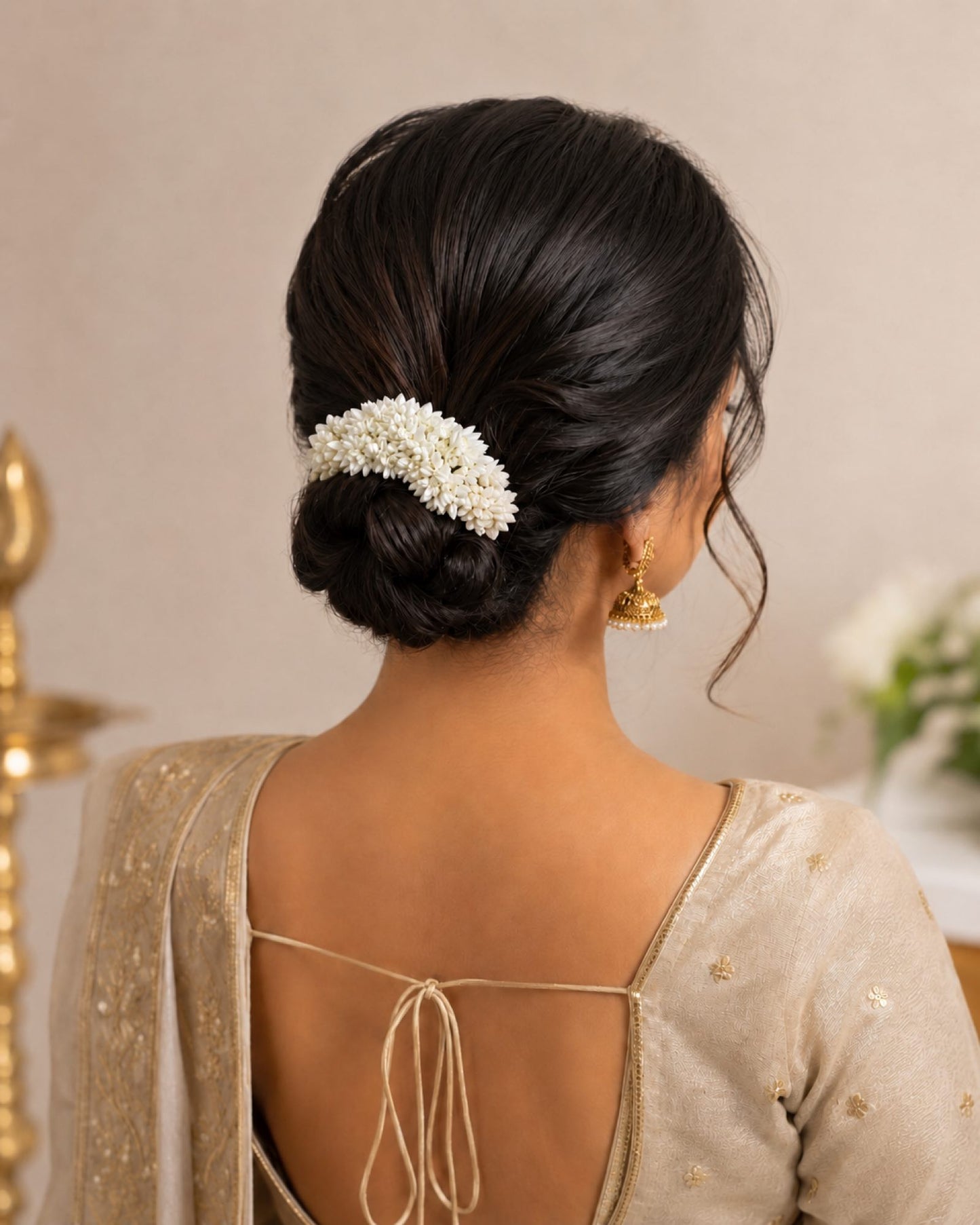 Styling reference showing an off-white gajra worn around a traditional hair bun.