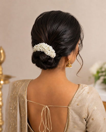 Styling reference showing an off-white gajra worn around a traditional hair bun.