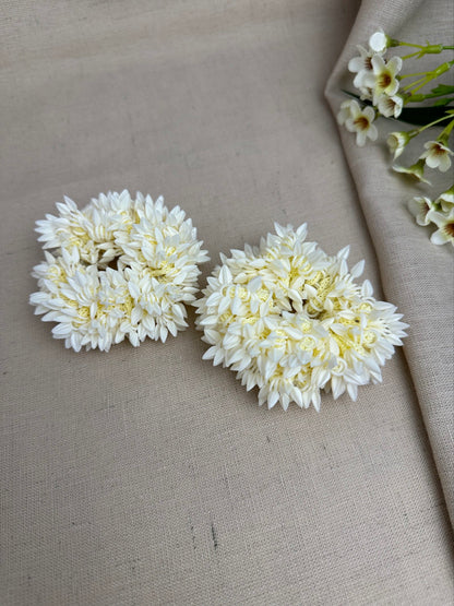 Pair of off-white reusable artificial gajras displayed on cream fabric.
