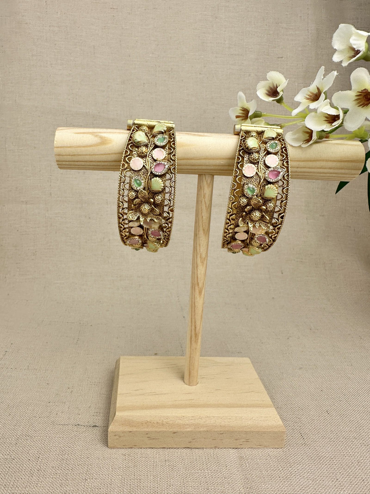 Set of two Rangnoor gold-plated pastel stone kangans displayed upright