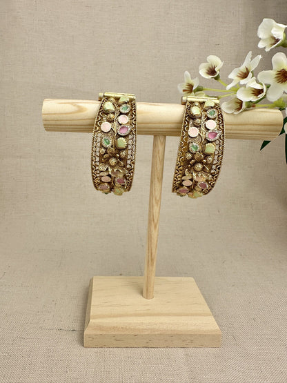 Set of two Rangnoor gold-plated pastel stone kangans displayed upright