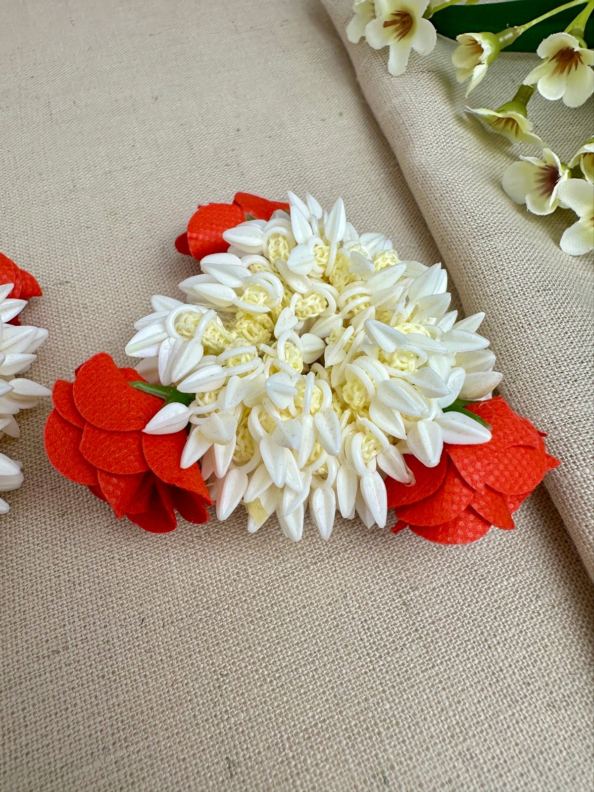 Close-up of red and off-white artificial gajras with small bud-like detailing.