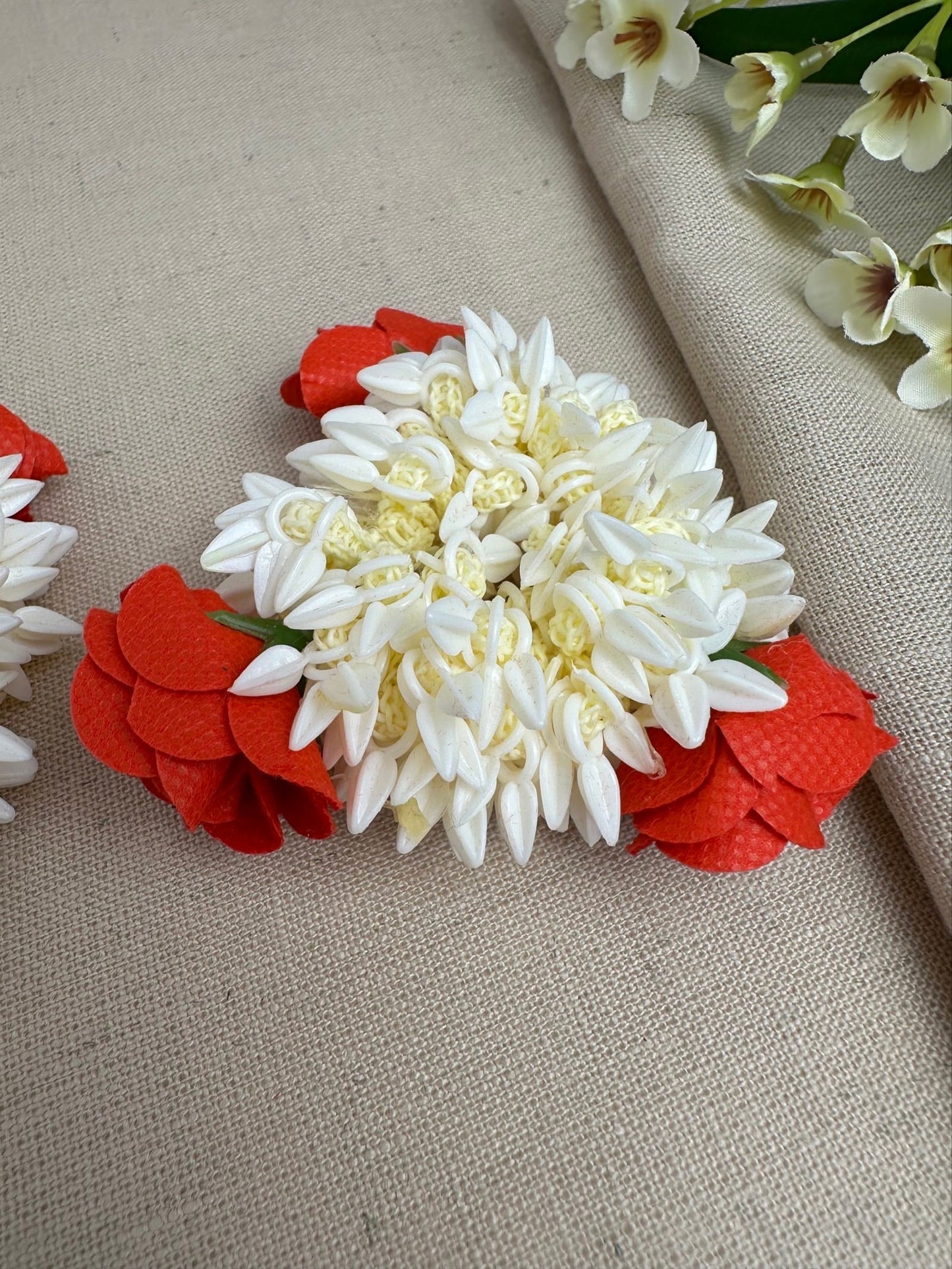Close-up of red and off-white artificial gajras with small bud-like detailing.