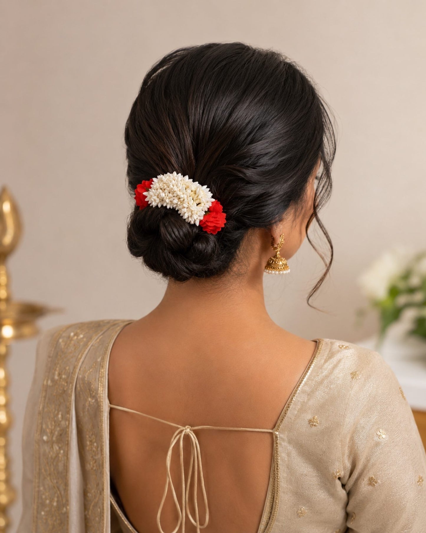 Styling reference showing a red and off-white gajra worn around a hair bun.