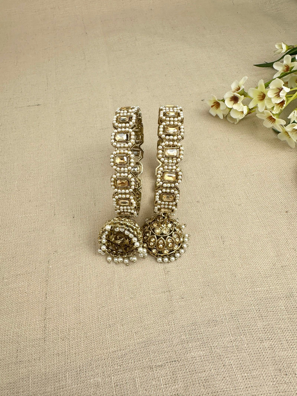 Close view of Saanjh Champagne Gold kangans with pearls and hanging jhumkis