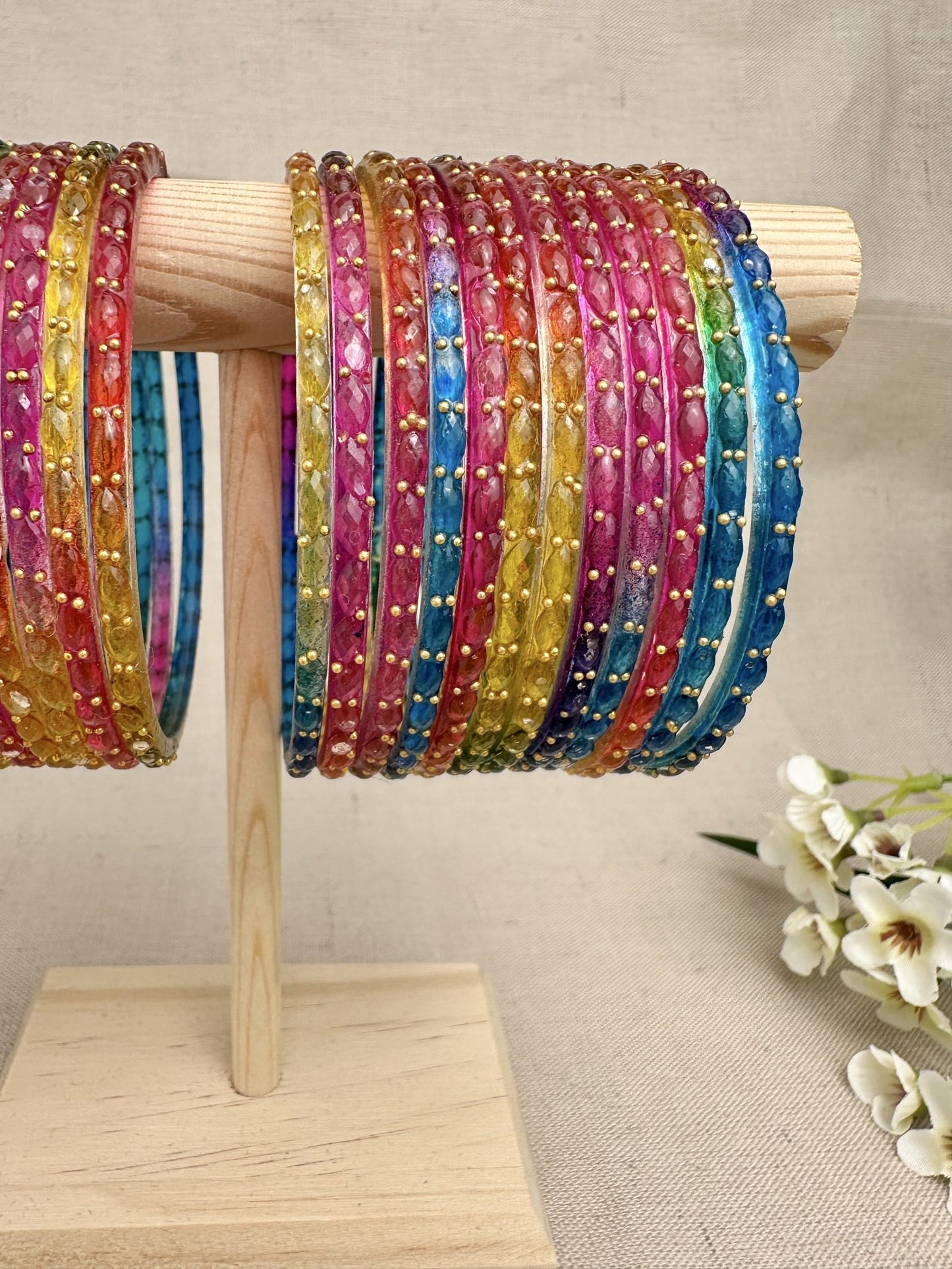    Close-up of multicolour Water Drop glass bangles with gold-tone dotted detailing