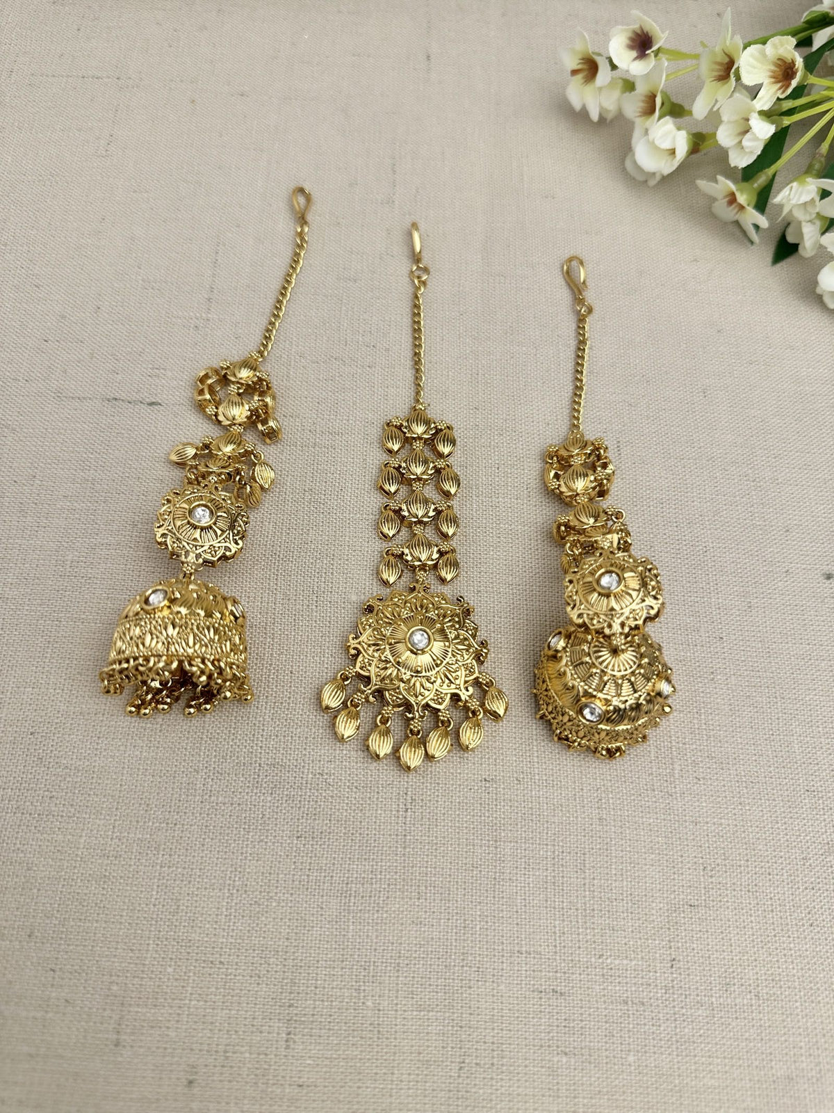 Side view of the Simran Gold-Plated Punjabi Jhumki & Tikka Set highlighting the single jhumki design and sahara chain.